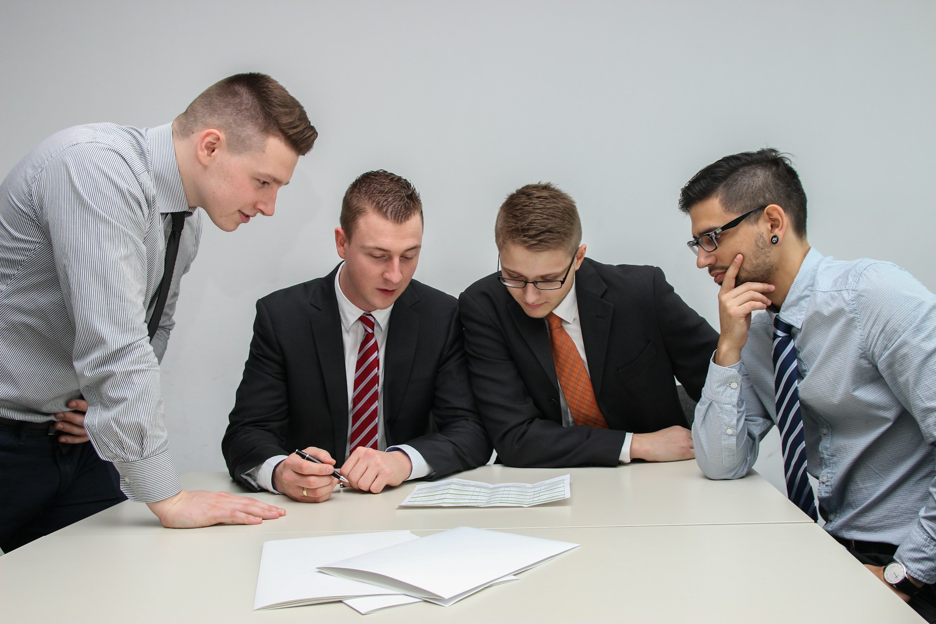 Corporate financiers collaborating around a table and discussing financial documents